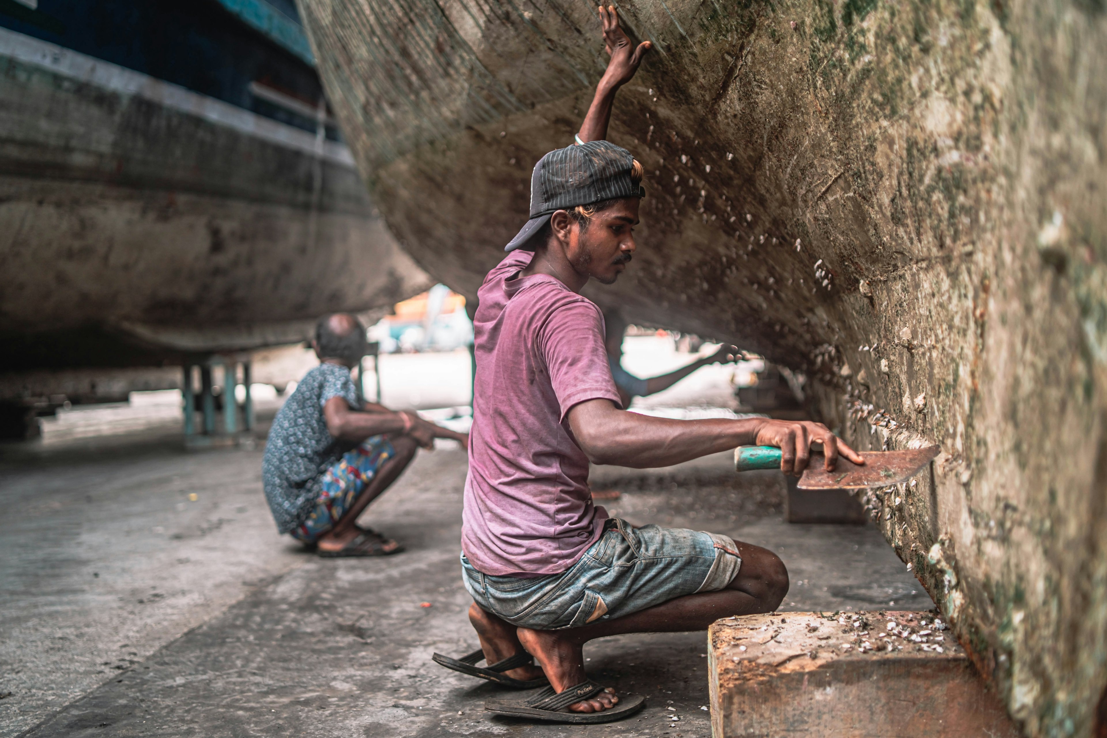 mo-hUg6vew8_two_men_working_on_a_boat_in_a_shipyard_5660x3773